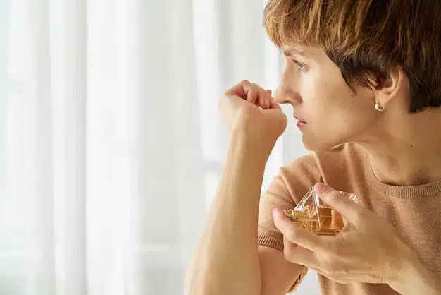 female trying smell perfume bottle loss smell due sarscov long covid syndrome 73872 4149