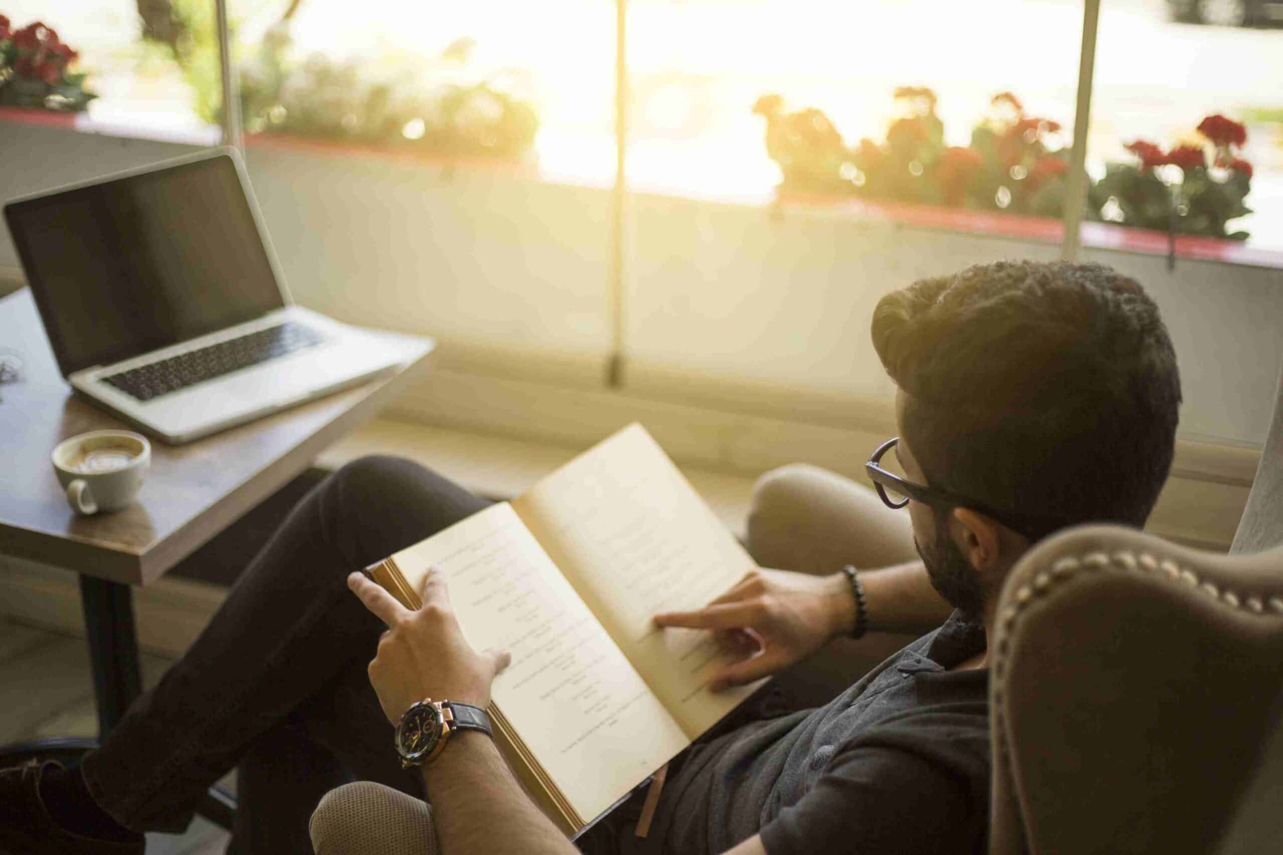young man reading a book in a cafe 690174172 59a09e020d327a00101050a6 scaled 2